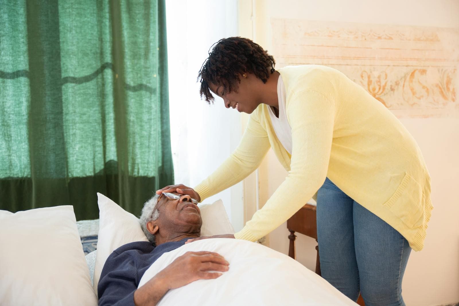 Family caregiver gently caring for her elderly father at home, illustrating respite care in a domestic setting